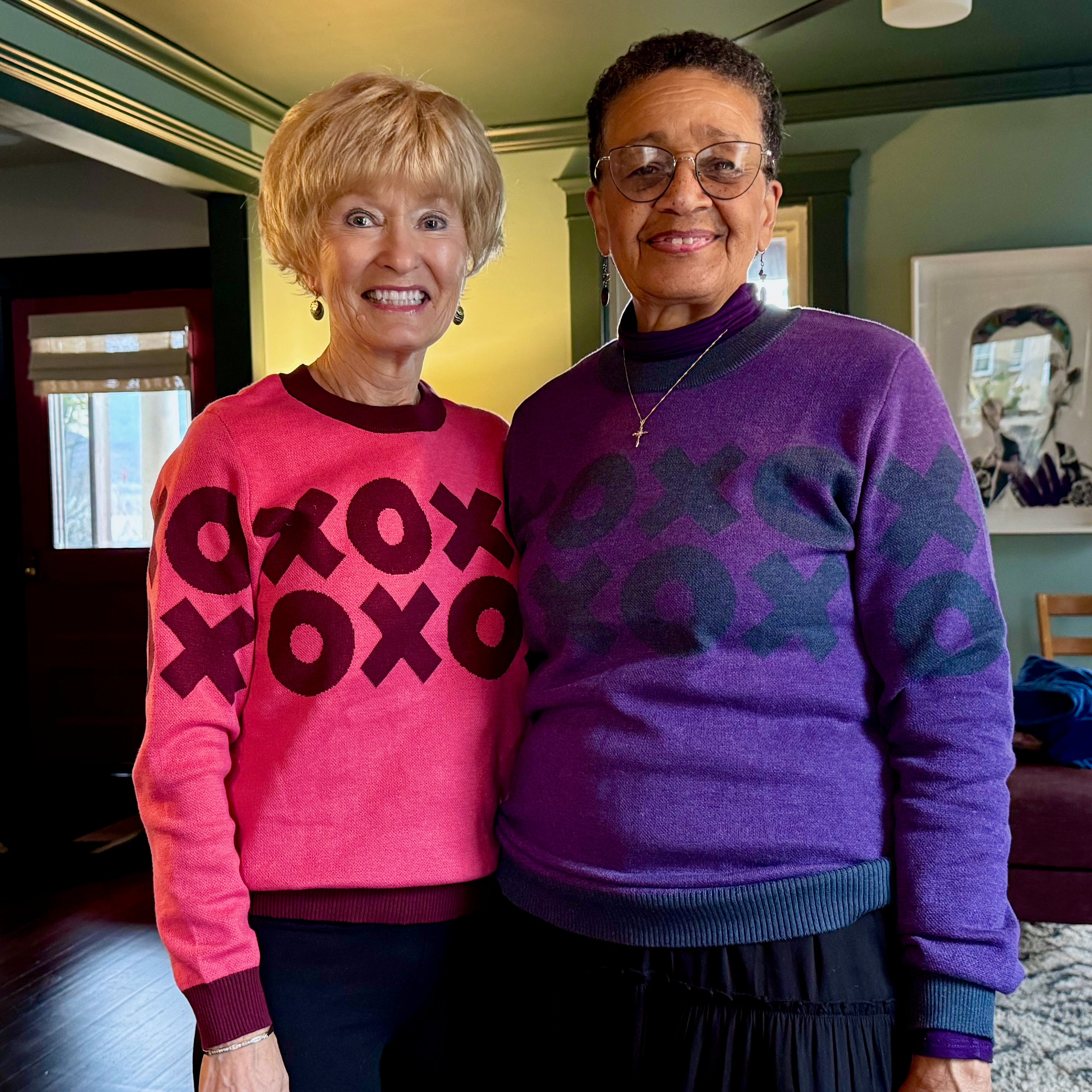 Peg and Carolyn wearing matching XOXO graphic knit sweaters