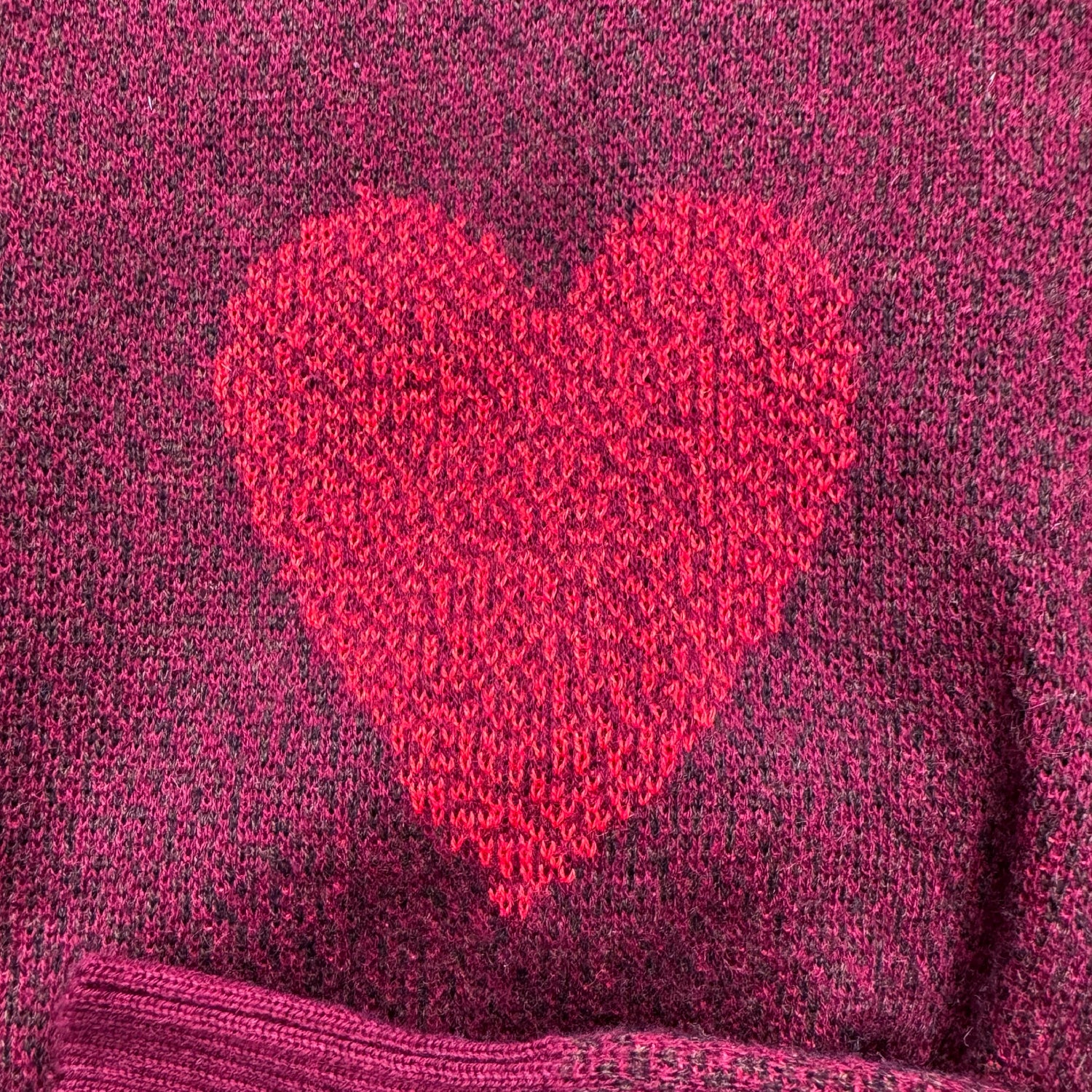 Close-up of the heart knit detail on the burgundy Heart On My Sleeve graphic sweater by Jedd
