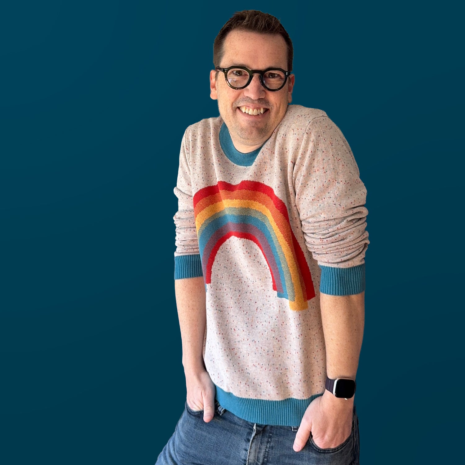 Jedd modeling the Over the Rainbow graphic knit sweater — bold rainbow design, original artist knitwear by Jedd