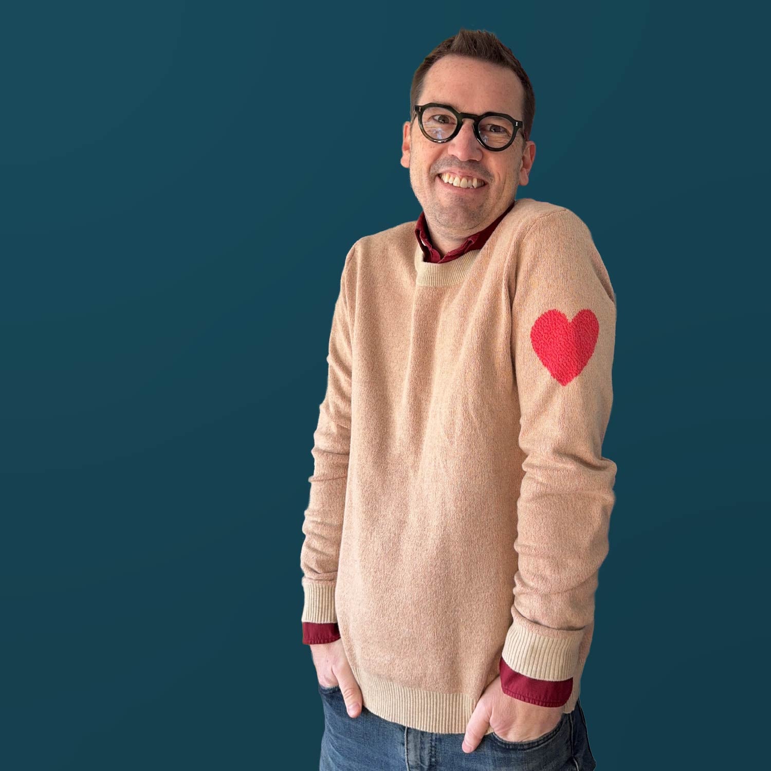 Jedd wearing the Heart On My Sleeve heather cream graphic knit sweater — artist-made designer fashion