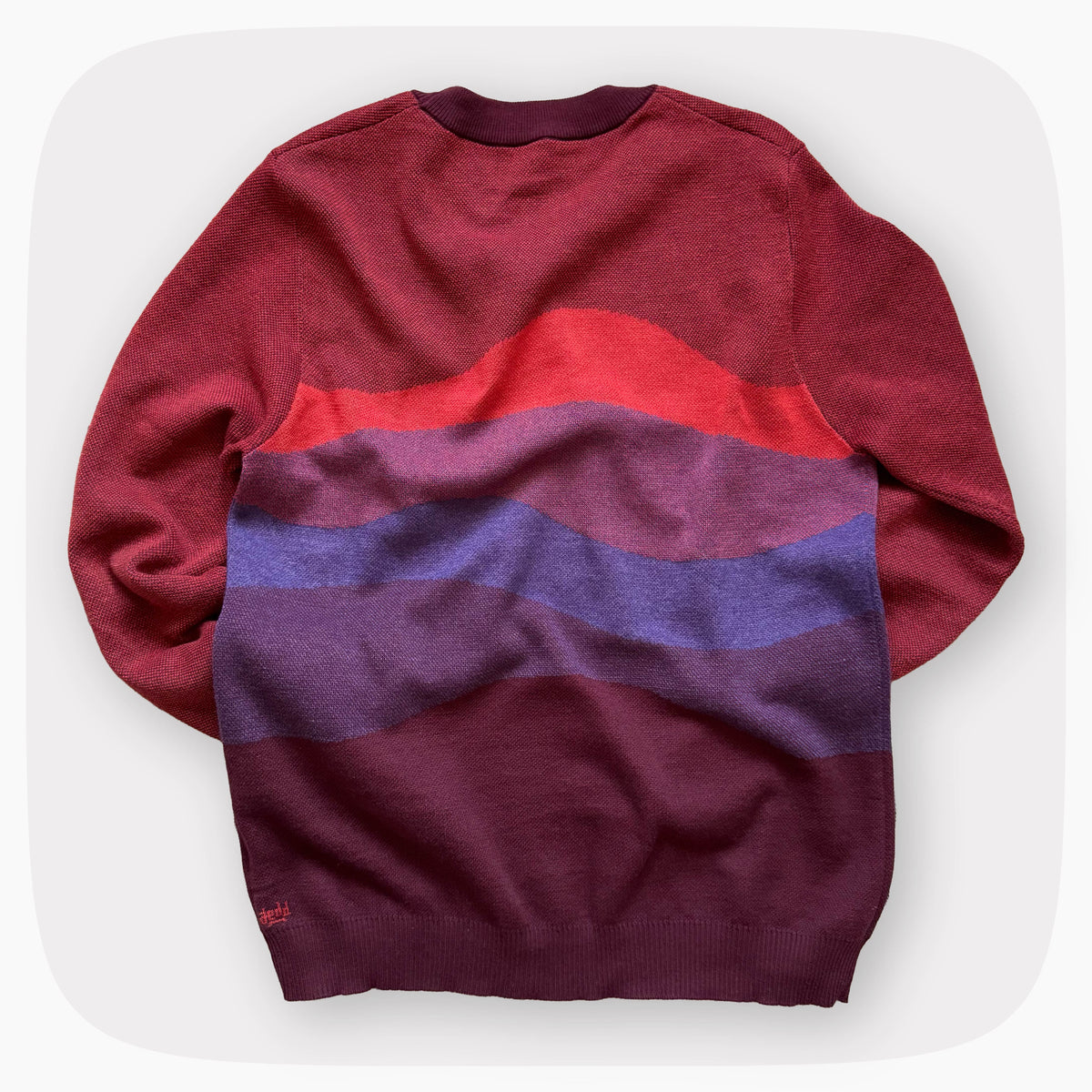 A red sweater with a patter that fades to darker red at the bottom.