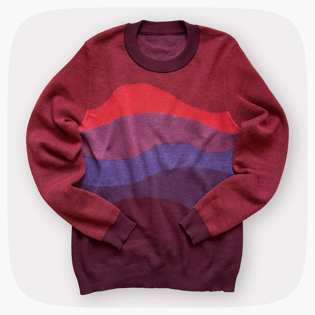 A red sweater with a patter that fades to darker red at the bottom.