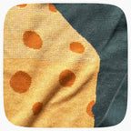 The detail of a green graphic knit sweater with a big piece of cheese design on the center.