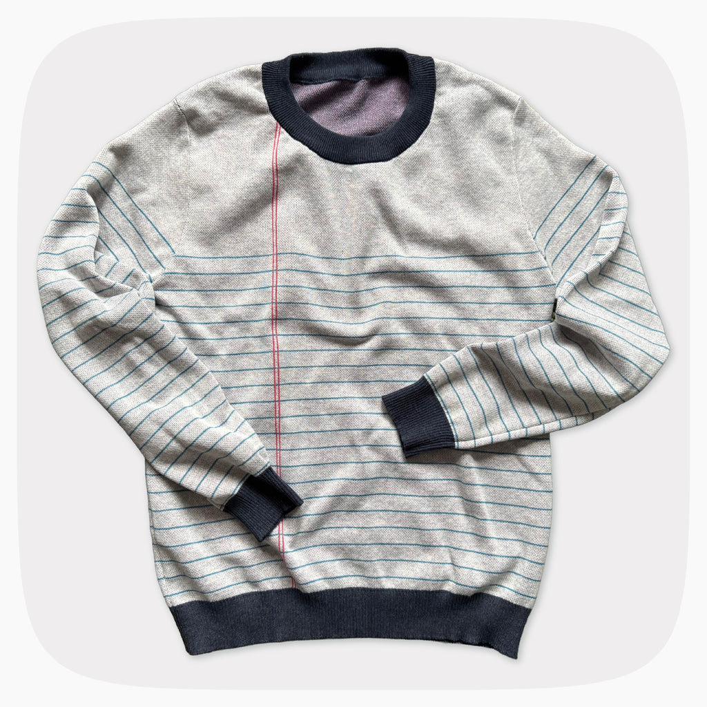 A graphic knit sweater with a pattern that looks like notebook paper.