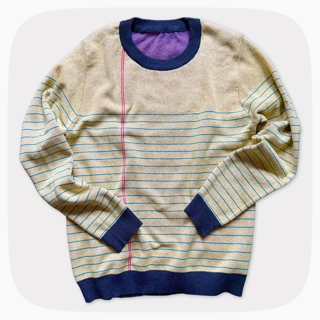 A graphic knit sweater with a pattern that looks like notebook paper.