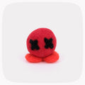 A small felted red ball with black X eyes and orange feet.
