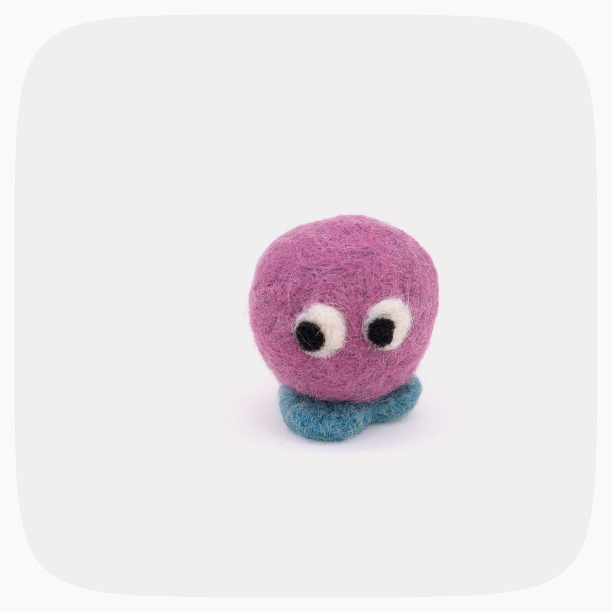 A small purple felted ball with eyes looking down and blue feet.
