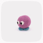 A small purple felted ball with eyes looking down and blue feet.