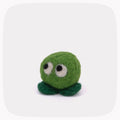 A small green felt plush toy with a round body, two dark green feet, and large white-and-black eyes, centered on a light gray background with rounded corners.