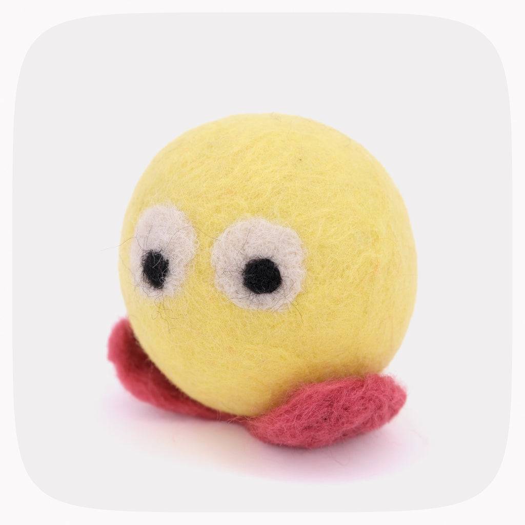 A yellow felted wool character toy with large white eyes, black pupils, and a pink mouth, shown on a light gray background with rounded corners.