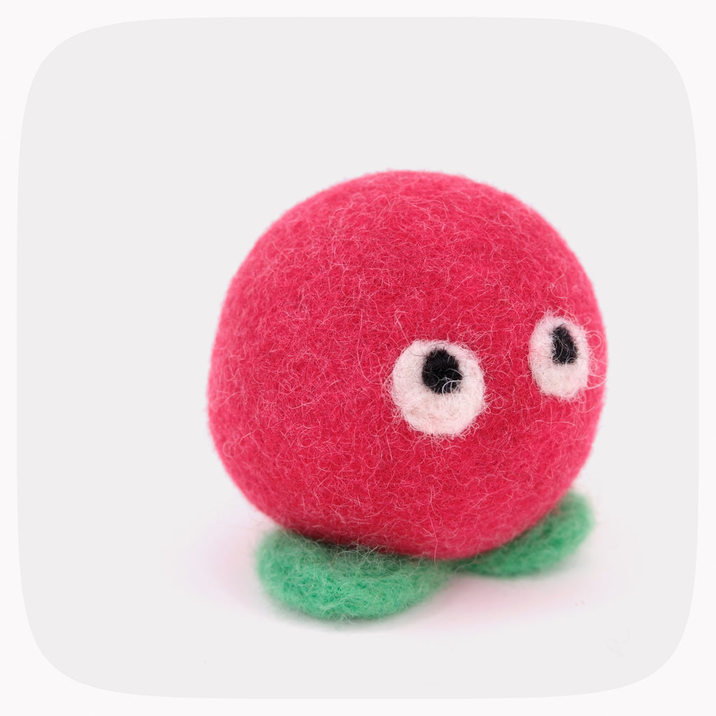 A red felted ball with eyes and light green feet.