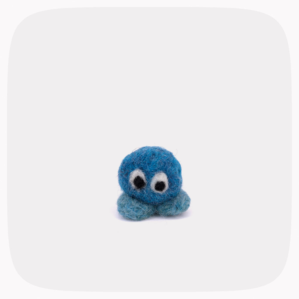 A small blue felted ball with eyes and light blue feet.