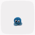 A small blue felted ball with eyes and light blue feet.