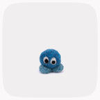 A small blue felted ball with eyes and light blue feet.
