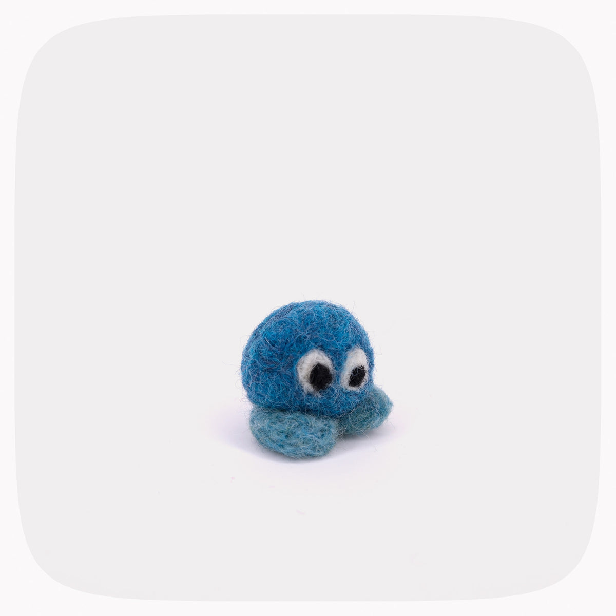 A small blue felted ball with eyes and light blue feet.