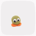 A small handmade felt toy with a round olive-green body, two large googly eyes, and two orange feet, centered on a light gray rounded-square background.