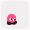 A small neon pink round felted character with black feet.