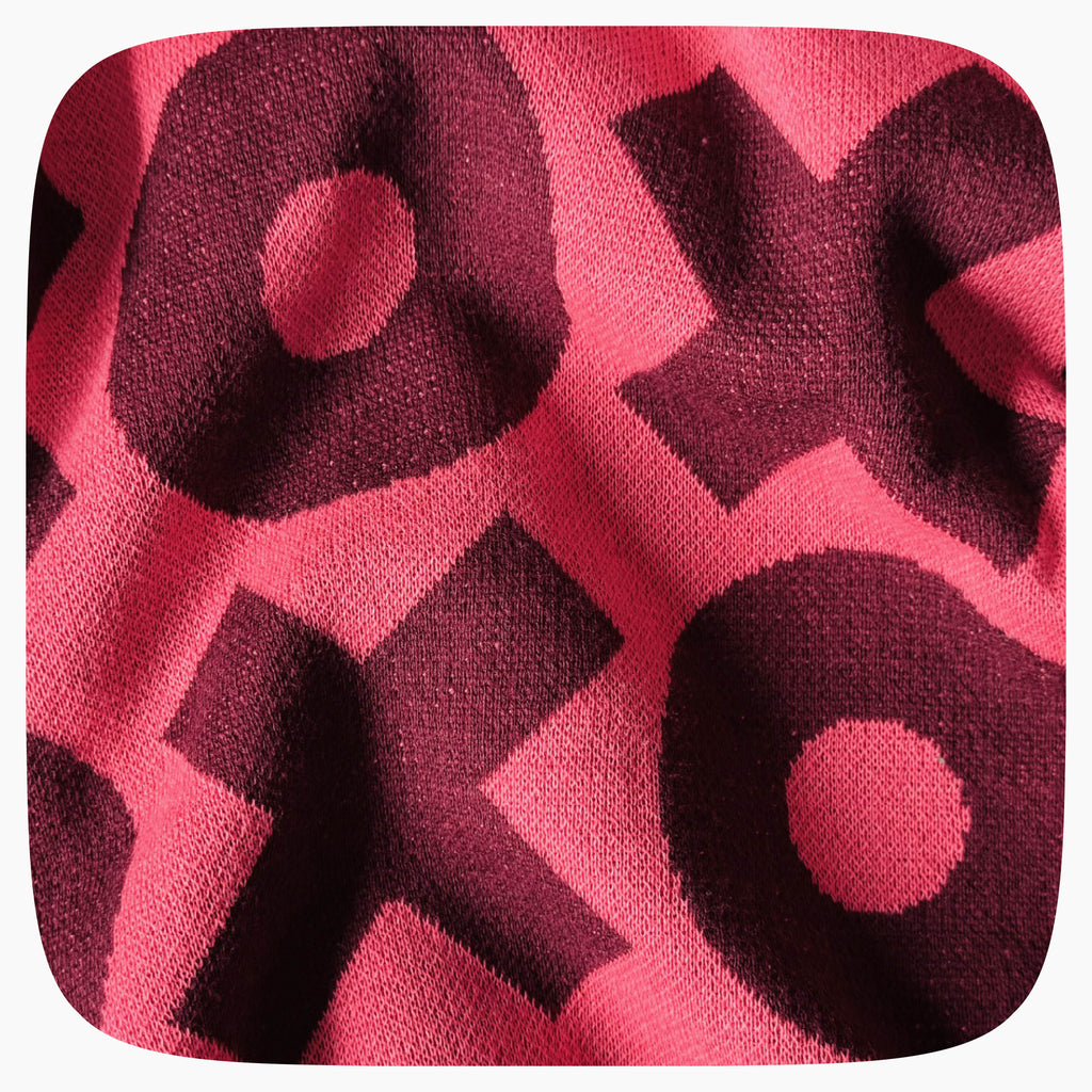 Detail view of a pink and red knitted XOXO pattern
