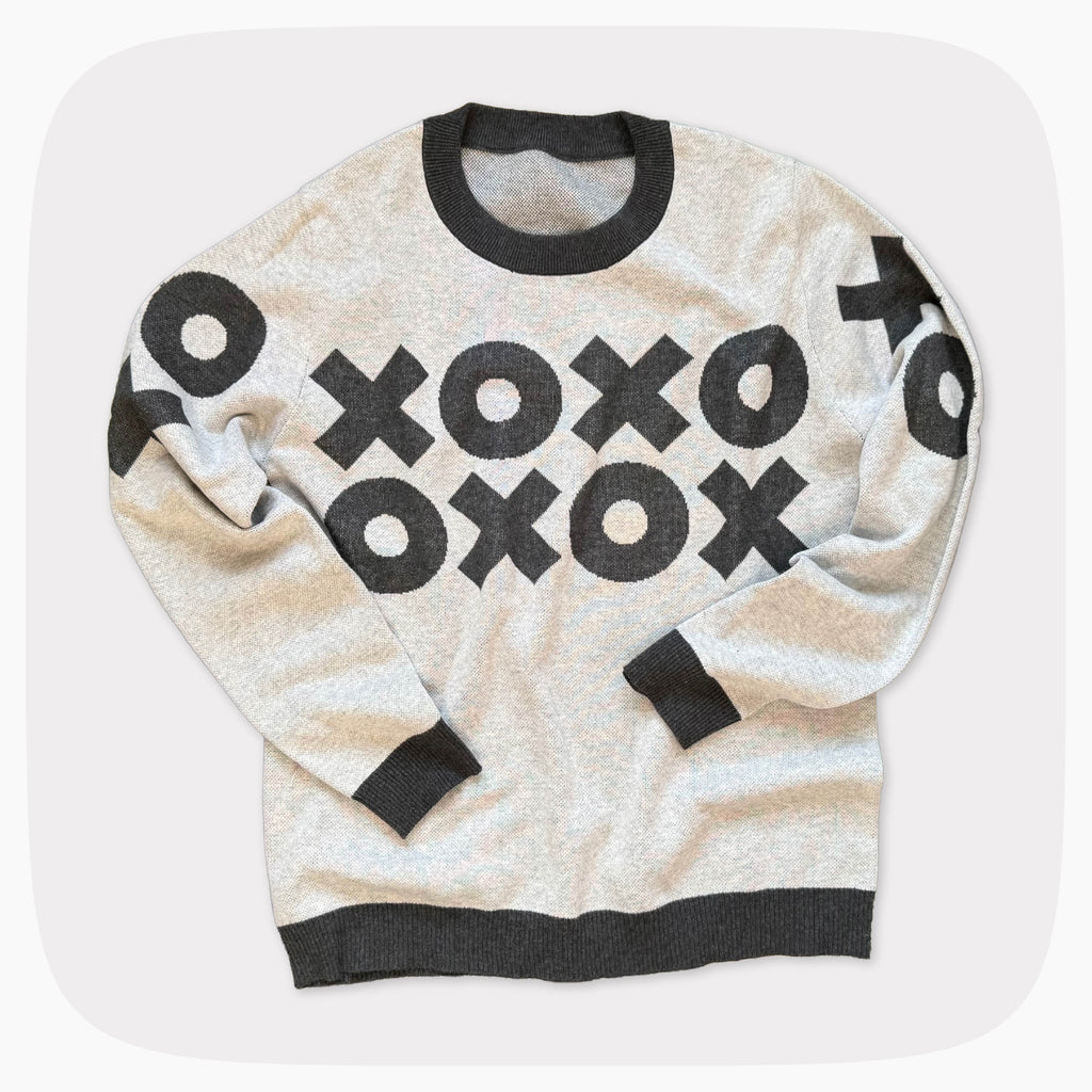 A gray graphic knit sweater with a dark red XOXO pattern across the chest.