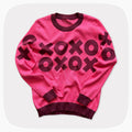 A pink graphic knit sweater with a dark red XOXO pattern across the chest.