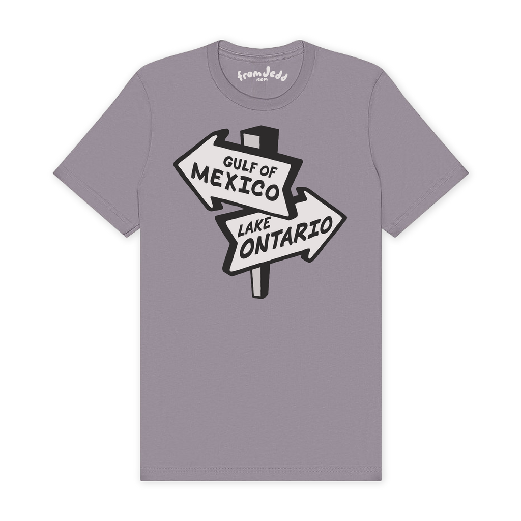 A light purple-gray crewneck t-shirt featuring a graphic of a road sign pointing to 'GULF OF MEXICO' and 'LAKE ONTARIO' in white and black.