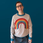 Jedd wearing the Over the Rainbow colorful graphic knit sweater — artist-made designer knitwear full of color