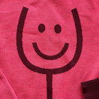 Close-up of the knitted wine glass design on the Happy Wine pink sweater by Jedd — jacquard knitwear detail