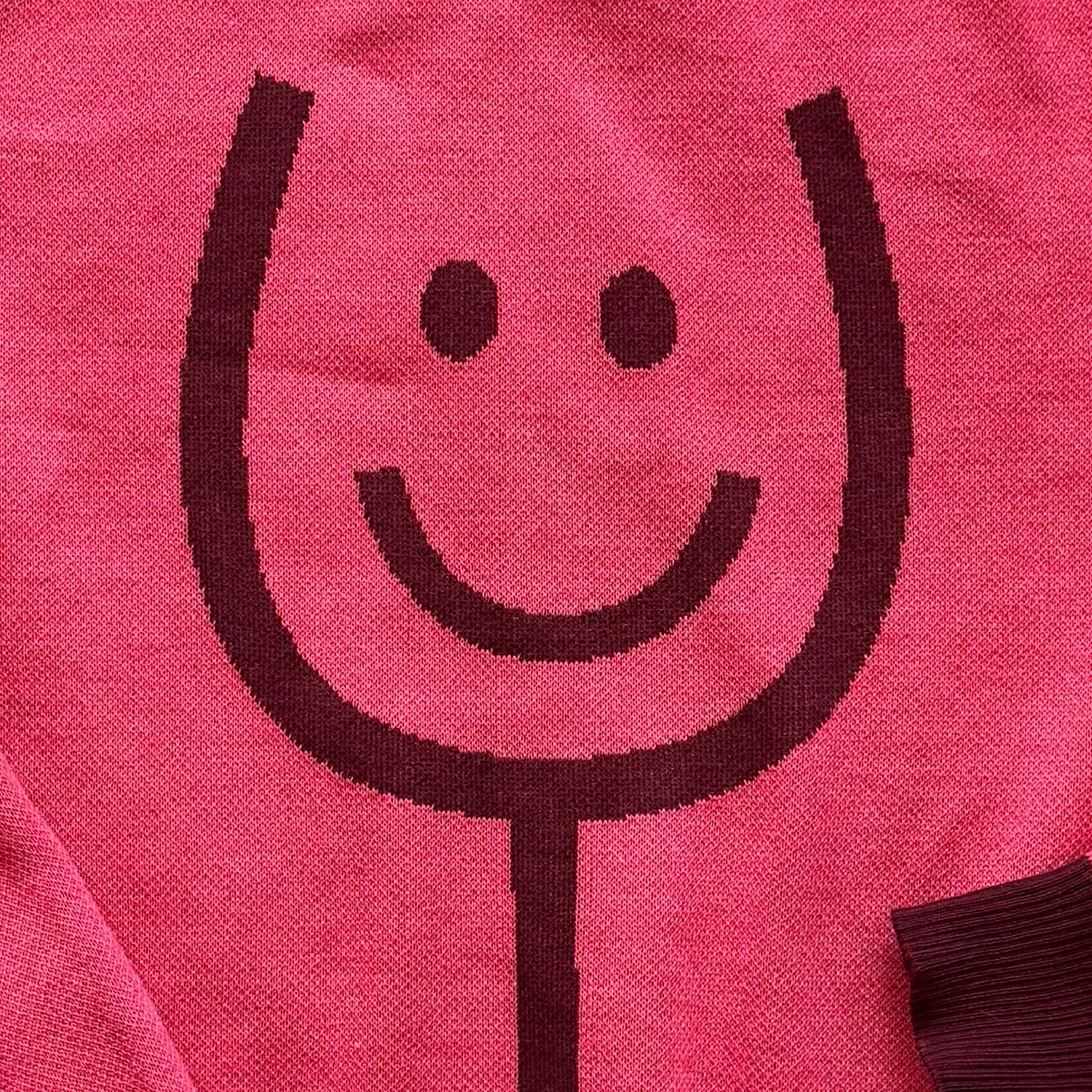 Close-up of the knitted wine glass design on the Happy Wine pink sweater by Jedd — jacquard knitwear detail