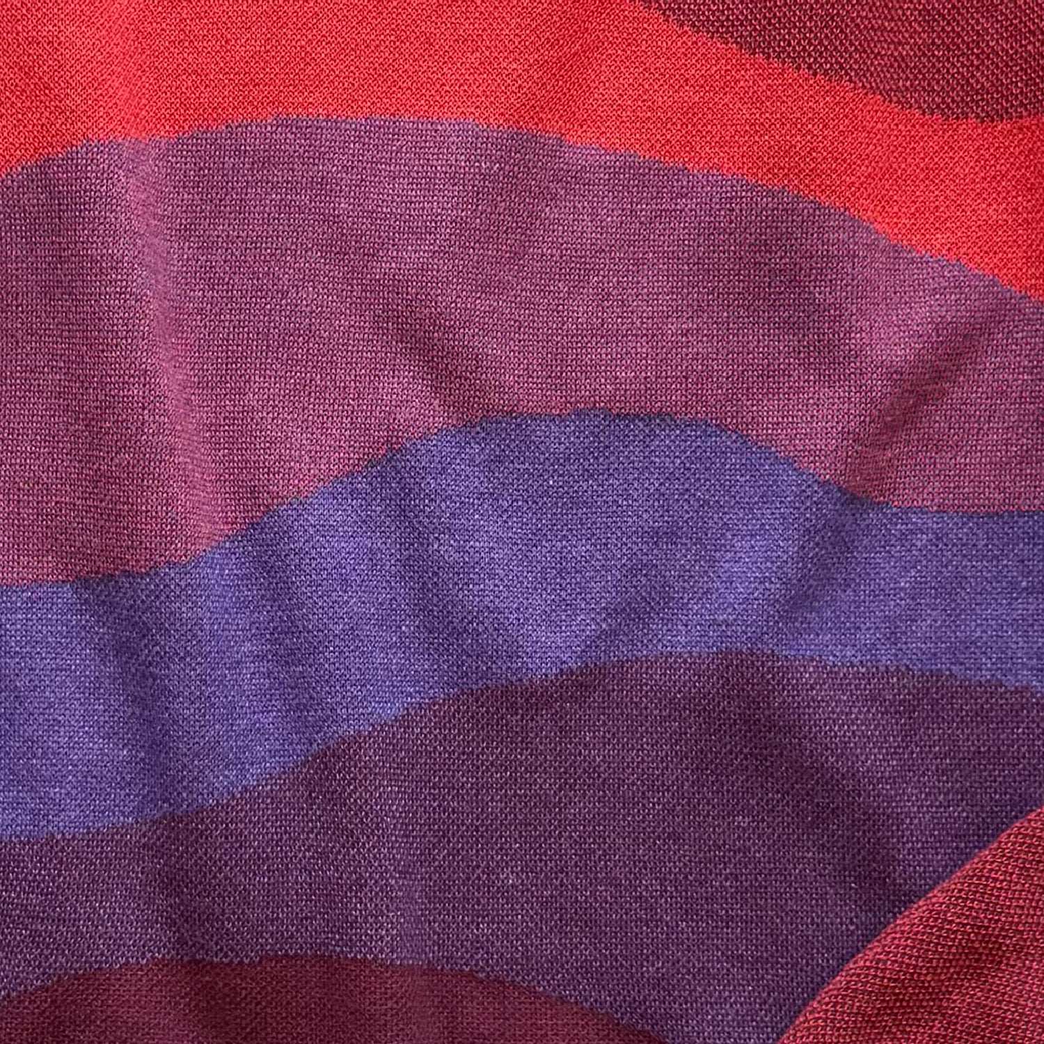 Detail of the knitted horizon layers on the Horizons red sweater by Jedd — jacquard knit texture