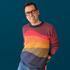 Jedd wearing the Horizons sunset graphic knit sweater — artist-designed layered colorway knitwear