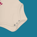 Beige baby onesie with buttons on a blue background