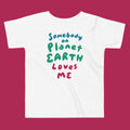 White t-shirt with colorful text 'Somebody on Planet Earth Loves Me' on a magenta background