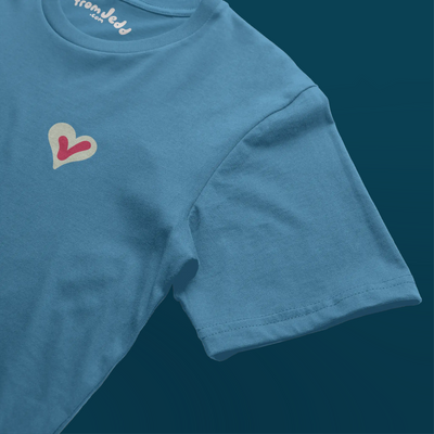 Detail of the sleeve on a blue t-shirt with a heart and a voting check mark design and an inside neck logo that says From Jedd