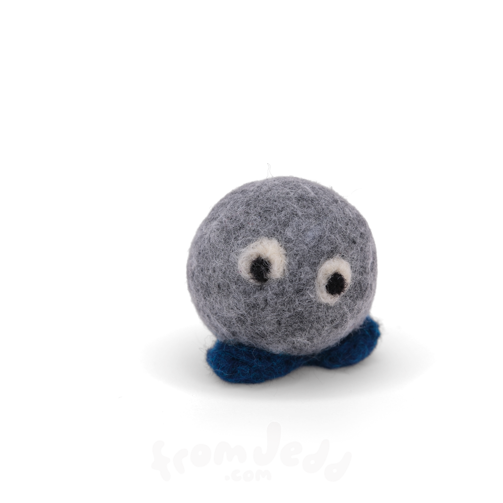 A small felt plush sculpture with a round gray body, white and black eyes, and dark blue feet, photographed on a clean white background.