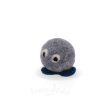 A small felted wool sculpture character with a round gray body, dark blue feet, and two white-and-black bead eyes, photographed on a clean white background.