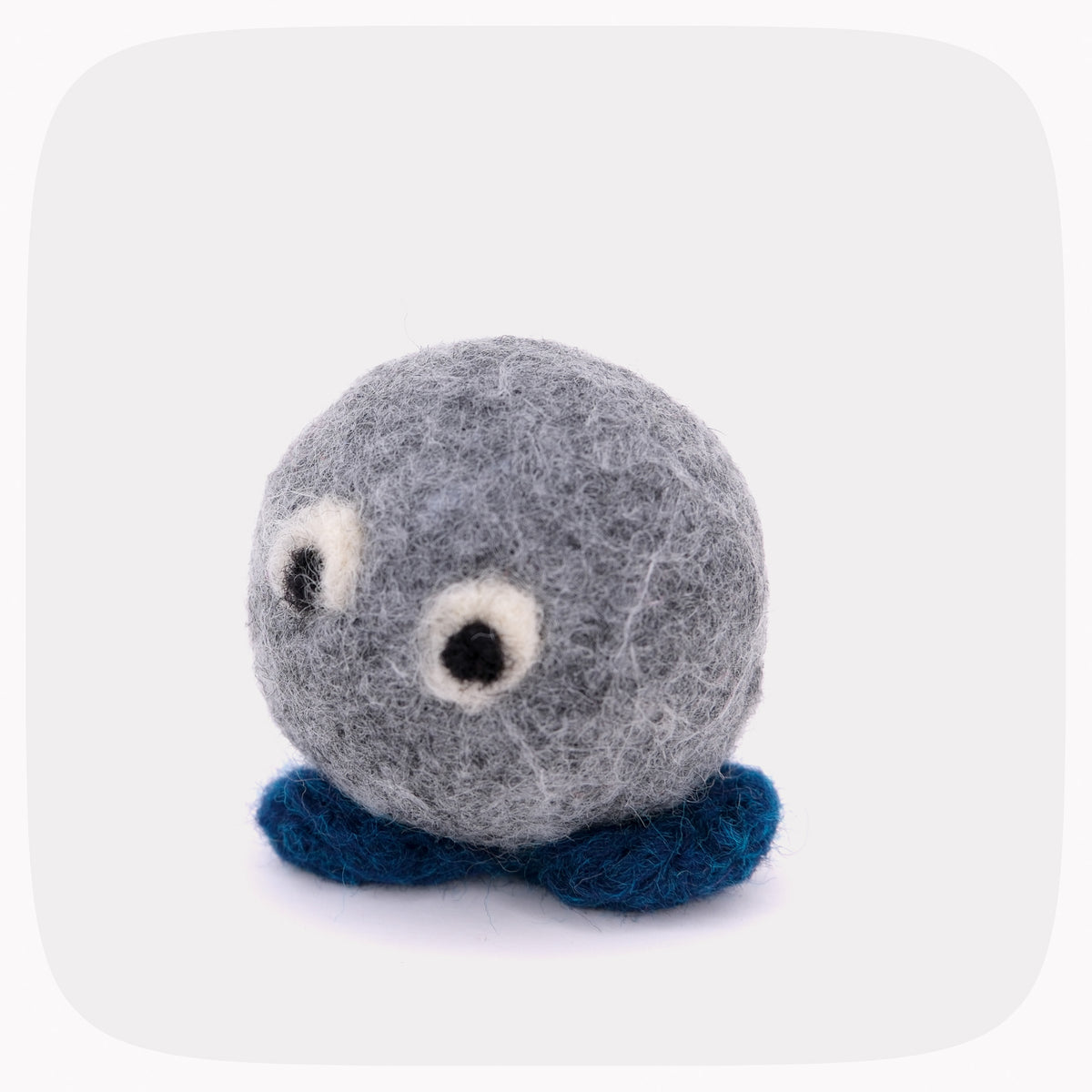 A gray felted ball with eyeballs and blue feet.