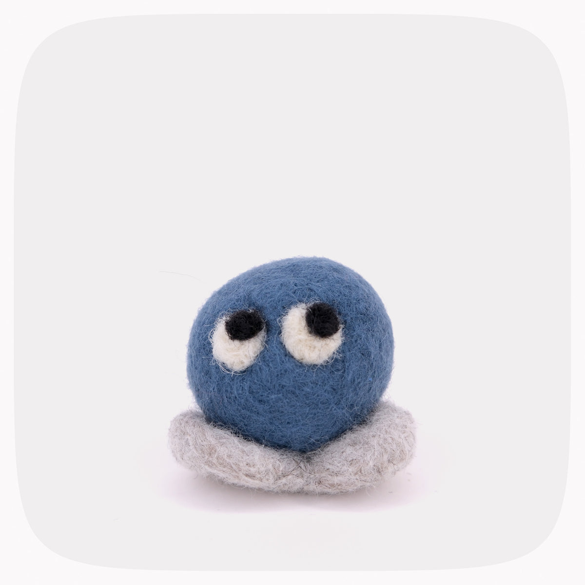 A blue felted circle with eyes and gray feet.
