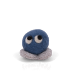 A blue felted creature with eyes looking up and grey feet.