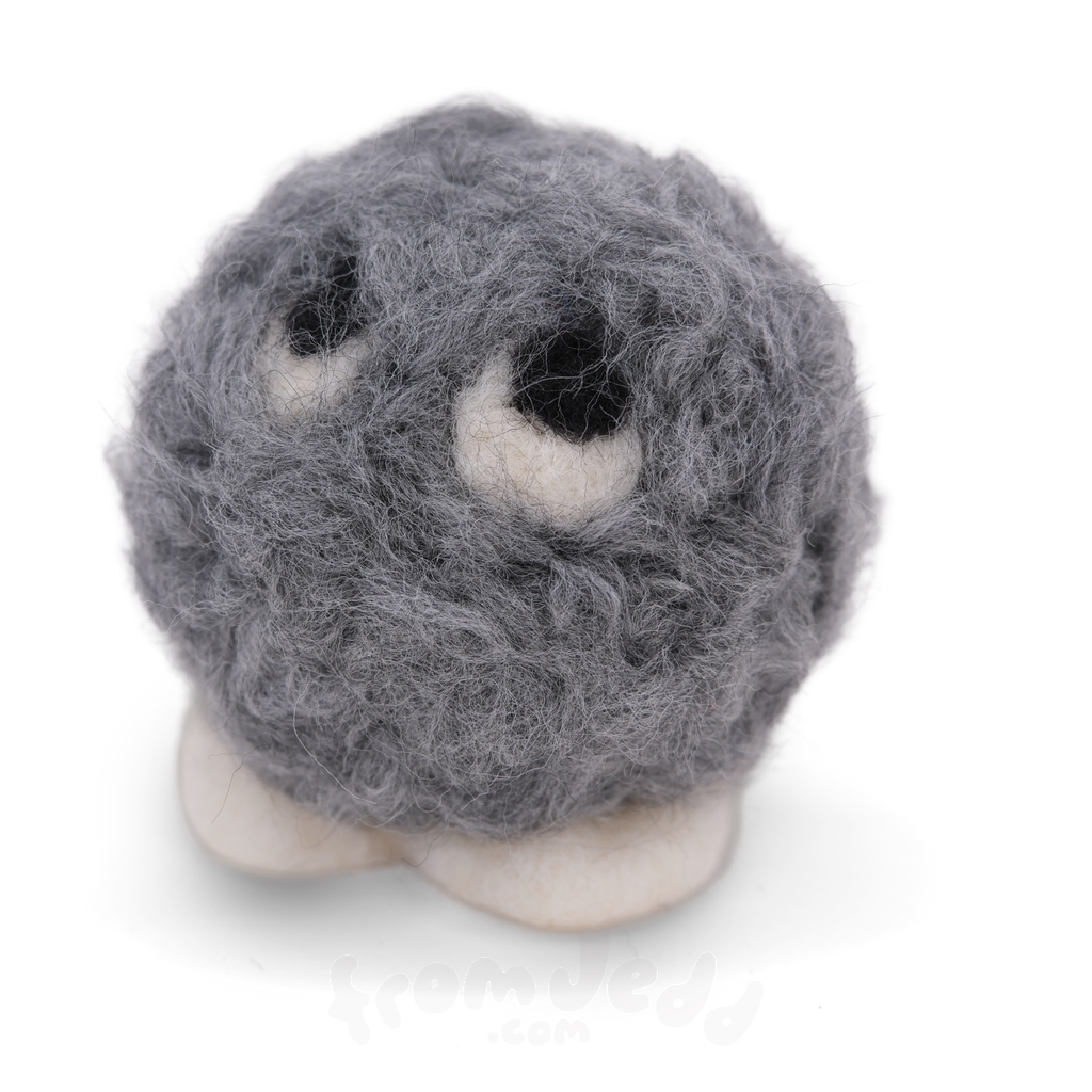 A small gray fuzzy ball character with white feet and large white eyes with black centers, photographed on a clean white background.