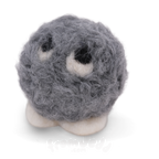 A small gray fuzzy ball character with white feet and large white eyes with black centers, photographed on a clean white background.