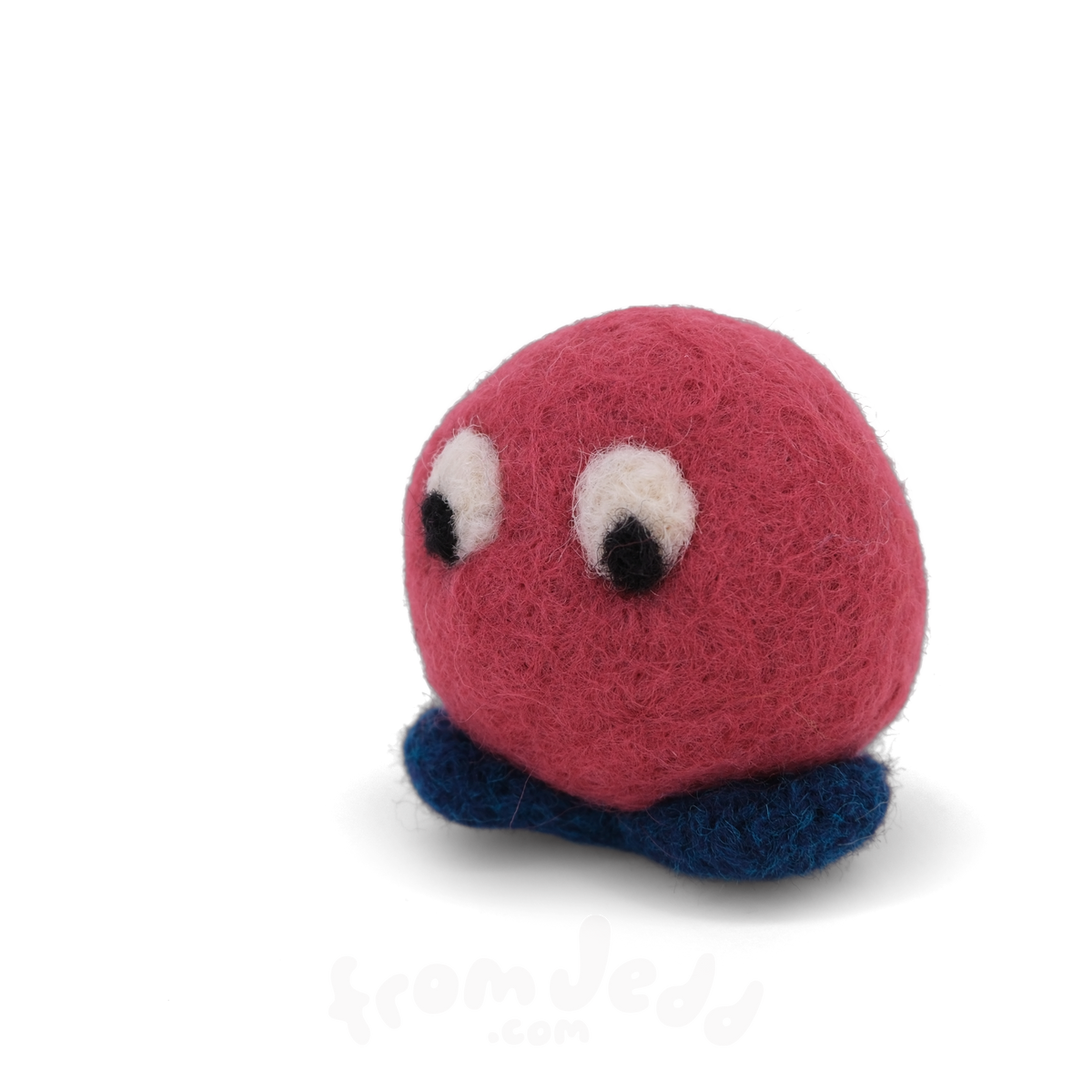 A small red felted creature with big eyes and blue feet