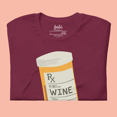 A folded maroon shirt with a prescription bottle illustration that reads "wine"
